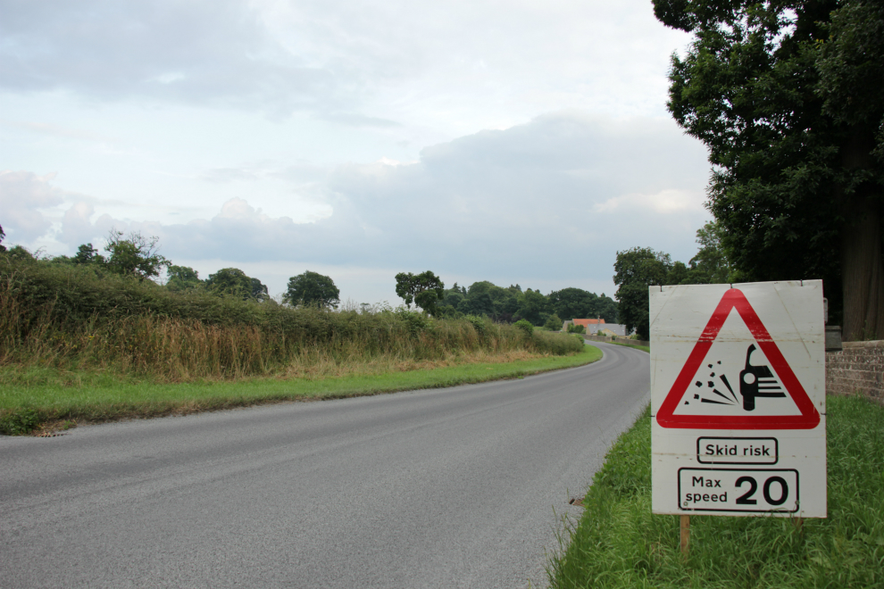 Loose chippings Skid risk Max 20mph sign Loose chippings Skid risk Max 20mph sign